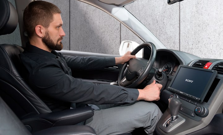 Image of the 22.7cm (8.95") DAB Media Receiver with WebLink Cast inside a car with a driver.