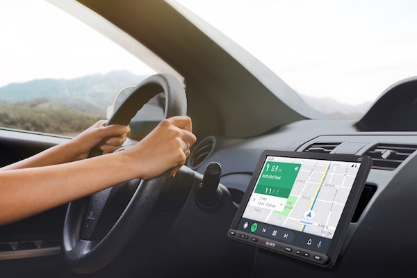 Image of the 22.7cm (8.95") DAB Media Receiver with WebLink Cast inside a car with a driver using Android Auto navigation.