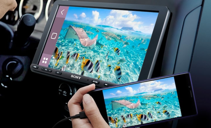 Image of the 22.7cm (8.95") DAB Media Receiver with WebLink Cast inside a car with a driver using WebLink connected via smartphone.